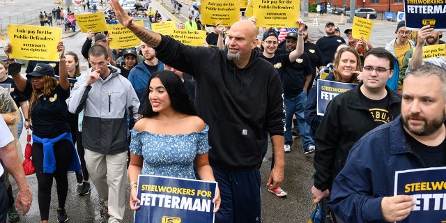 John and Gisele Fetterman walk with the United Steelworkers District 10 union during a Labor Day parade in Pittsburgh, Pennsylvania, on Sept. 5, 2022.