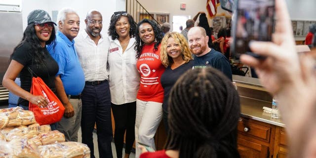Senator Raphael Warnock (D-GA), center, poses for a photo with supporters as well as U.S. Congresswoman Lucy McBath, second from right, and Georgia Democtratic Lieutenant Governor candidate Charlie Bailey, right, at a Labor Day picnic on September 5, 2022 in Atlanta, Georgia.