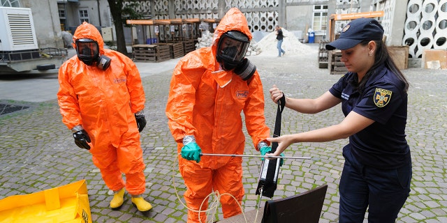 Ukrainian Emergency Ministry rescuers wear protective clothing during a nuclear emergency training session for civilians in Kyiv on Sept. 7, 2022.