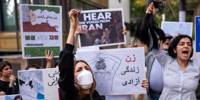 A member of the Iranian community in Seoul shouts slogans after cutting her hair outside the Embassy of the Islamic Republic of Iran during a demonstration to defend women's rights in Iran on September 28, 2022 in Seoul, South Korea. During the protest , asked the Iranian police for an investigation into Mahsa Amini's death.  The 22-year-old Kurdish woman died on September 16 of a heart attack and coma suffered in a police station in the country.  Amini was arrested by the moral police for not wearing the veil correctly and was taken to a police station to attend 