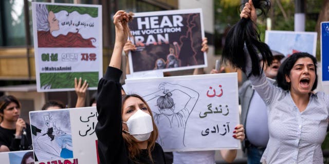 Members of the Iranian community in Seoul shout slogans after having their hair cut outside the Embassy of the Islamic Republic of Iran during a rally to defend the rights of Iranian women in Seoul, South Korea, September 28, 2022. . During the protests, they demanded the Iranian police to investigate the death of Mercer Amini.  A 22-year-old Kurdish woman died on September 16 from a heart attack and coma sustained at the country's police station. Amini was detained by the moral police for not wearing the veil properly and was taken to the police station to attend a 