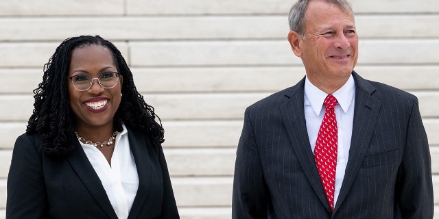 U.S. Supreme Court Justice Ketanji Brown Jackson speaks with Chief Justice John Roberts on the steps of the US Supreme Court, following her investiture ceremony in Washington, D.C., September 30, 2022. 