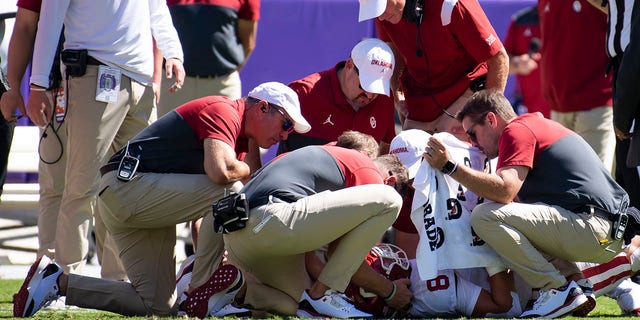 Coaches surround quarterback Dillon Gabriel (8) of the Oklahoma Sooners as he lies on the field after taking a hit from linebacker Jamoi Hodge of the TCU Horned Frogs in the second quarter at Amon G. Carter Stadium Oct. 1, 2022, in Fort Worth, Texas. Hodge was disqualified from the game. 