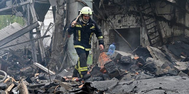 A firefighter walks among the ruins of a destroyed electrical products plant following missile strikes in Kharkiv on October 4, 2022, amid the Russian invasion of Ukraine. 