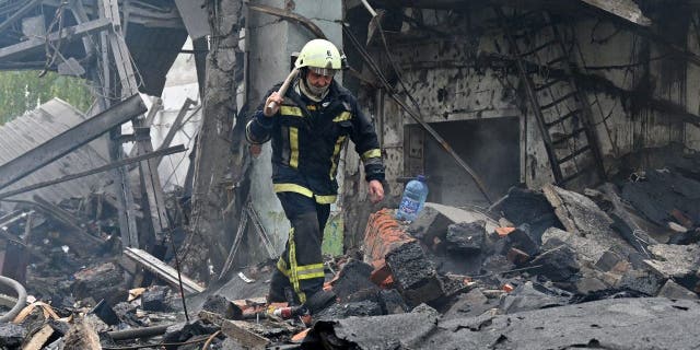A firefighter walks among the ruins of a destroyed electrical products plant following missile strikes in Kharkiv on October 4, 2022, amid the Russian invasion of Ukraine.