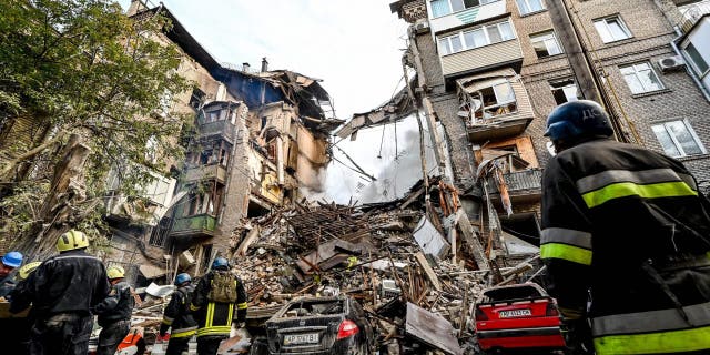 Ukrainian firefighters put out a fire after a strike in Zaporizhzhia on October 6, 2022, during the Russian invasion of Ukraine.