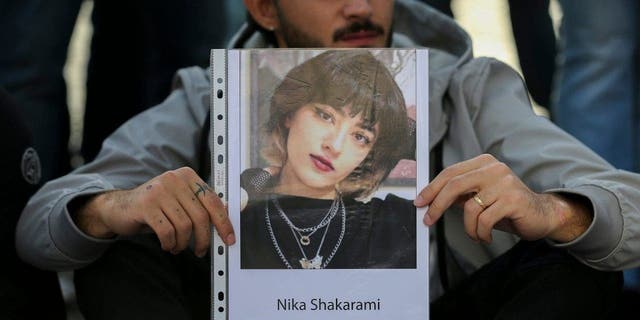 NAPLES, ITALY - 2022/10/06: A man with a photograph of Iranian woman Nika Shakarami, during the demonstration in Naples for the freedom of Iranian women, after the recent riots in Iran and the killing of Mahsa Amini. (Photo by Marco Cantile/LightRocket via Getty Images)