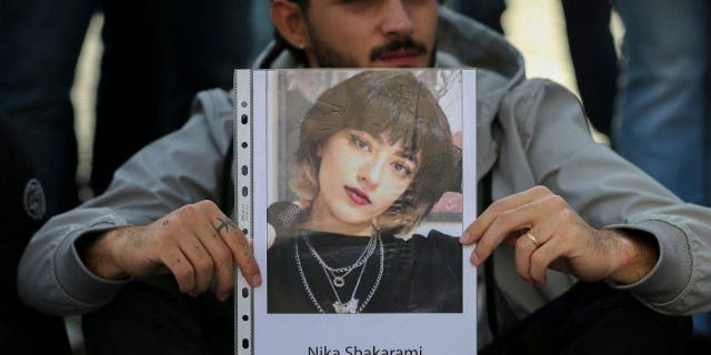 NAPLES, ITALY - 2022/10/06: A man with a photograph of Iranian woman Nika Shakarami, during the demonstration in Naples for the freedom of Iranian women, after the recent riots in Iran and the killing of Mahsa Amini. (Photo by Marco Cantile/LightRocket via Getty Images)