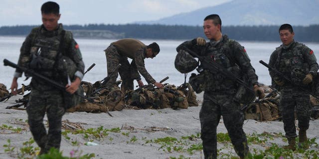 South Korean (foreground) and U.S. Marines participate in a joint amphibious landing exercise with their Filipino counterparts on a beach overlooking the South China Sea in the city of San Antonio, Zambales province, Oct. 