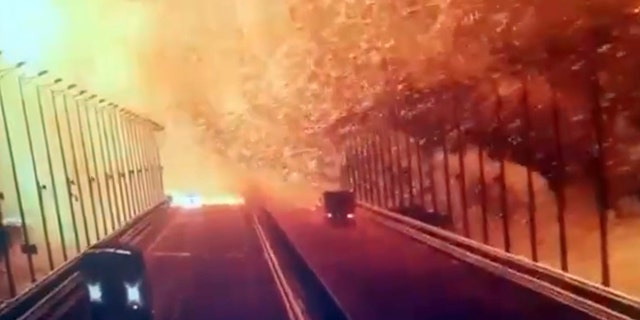 A screen grab from surveillance footage shows flames and smoke following an explosion at the Kerch Bridge (also known as the Crimean Bridge) in the Kerch Strait, Crimea, on October 8, 2022. 