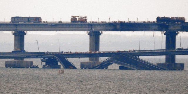 Workers restore the railway tracks on the Kerch bridge that links Crimea to Russia, near Kerch, on October 9, 2022, a day after it was damaged by a blast. - Divers were to inspect the waters beneath the Crimea bridge on October 9, 2022 a day after a huge blast damaged Russia's key road and rail link to the annexed peninsula, killing three people. (AFP via Getty Images)