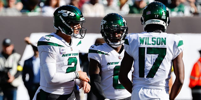 New York Jets quarterback Zach Wilson, #2, talks with New York Jets wide receiver Elijah Moore, #8, and New York Jets wide receiver Braxton Berrios, #10, during the National Football League game between the New York Jets and Miami Dolphins on Oct. 9, 2022 at MetLife Stadium in East Rutherford, New Jersey.