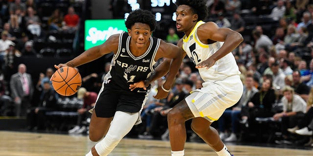 Joshua Primo #11 of the San Antonio Spurs drives into Collin Sexton #2 of the Utah Jazz during a game at Vivint Arena on Oct. 11, 2022, in Salt Lake City, Utah. 