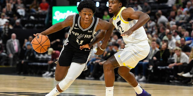 Joshua Primo #11 of the San Antonio Spurs drives into Collin Sexton #2 of the Utah Jazz during a game at Vivint Arena on Oct. 11, 2022, in Salt Lake City, Utah. 