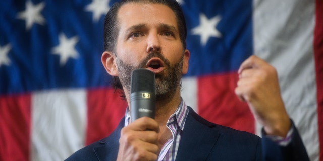 A photo of Donald Trump Jr in front of an American flag