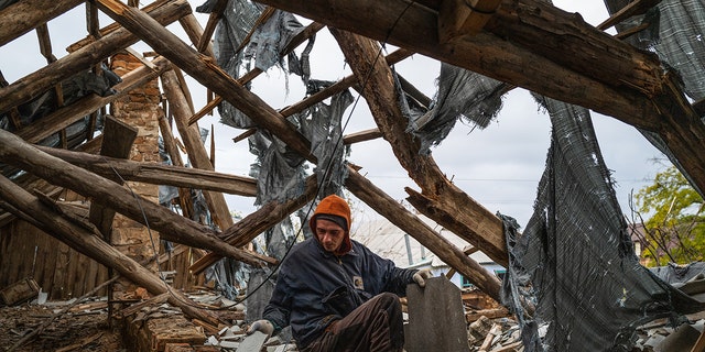 KHERSON OBLAST, UKRAINE - OCTOBER 27: A worker collects wood and roofing materials in a destroyed home in the recently retaken village of Velyka Oleksandrivka in Kherson, Ukraine on October 27, 2022 as Russia-Ukraine war continues.