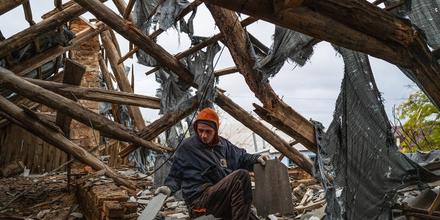 KHERSON OBLAST, UKRAINE - OCTOBER 27: A worker collects wood and roofing materials in a destroyed home in the recently retaken village of Velyka Oleksandrivka in Kherson, Ukraine on October 27, 2022 as Russia-Ukraine war continues.