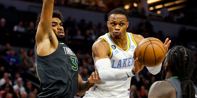 Russell Westbrook of the Los Angeles Lakers, center, passes the ball while Karl-Anthony Towns of the Minnesota Timberwolves, left, defends in the third quarter of a game at Target Center Oct. 28, 2022, in Minneapolis. The Timberwolves defeated the Lakers 111-102.