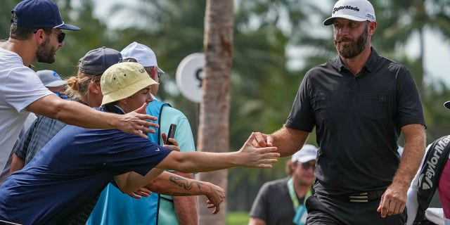 Team captain Dustin Johnson of 4 Aces GC punches fans between the ninth and tenth holes during the LIV Golf Invitational - Miami Team Championship Stroke Championship at Trump National Doral Miami on October 30, 2022 in Doral, Florida.