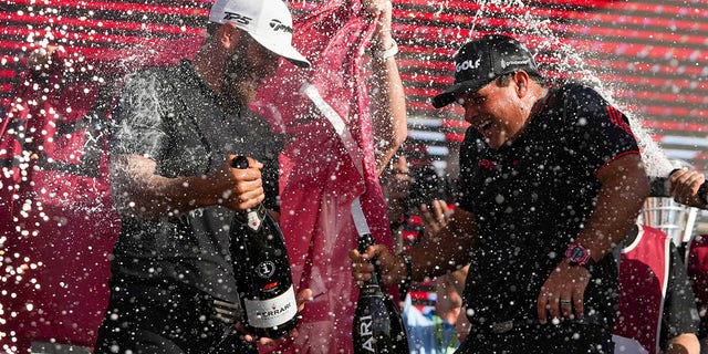 Team Captain Dustin Johnson of 4 Aces GC and Patrick Reed celebrate on the podium after the team championship stroke-play round of the LIV Golf Invitational - Miami at Trump National Doral Miami on October 30, 2022 in Doral, Florida.