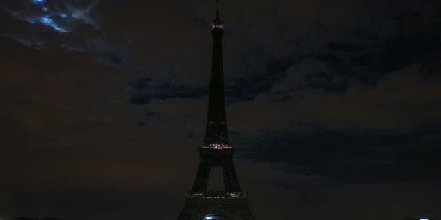The Eiffel Tower submerges into darkness as part of the Earth Hour switch-off on March 27, 2021.