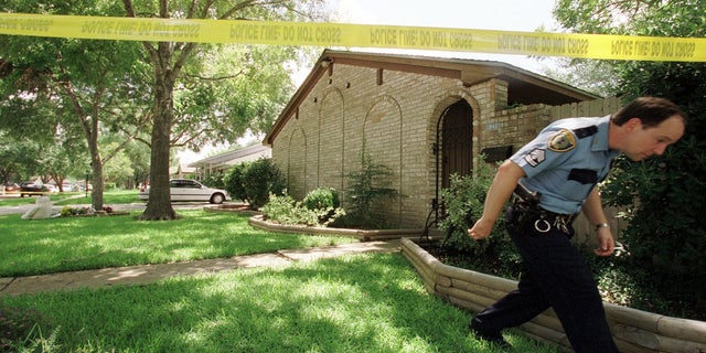 A Houston police officer exits the home where Andrea Yates, 36, allegedly killed her five children by drowning them in Clear Lake, a suburb of south Houston, TX. 