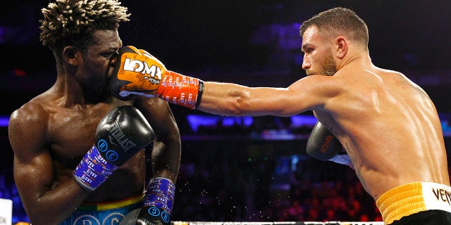 NEW YORK, NEW YORK - DECEMBER 11: Vasiliy Lomachenko (black trunks) trades punches with Richard Commey (blue trunks) at Madison Square Garden on December 11, 2021 in New York, New York.