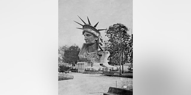 The head of the Statue of Liberty is shown on display in a park in Paris. 