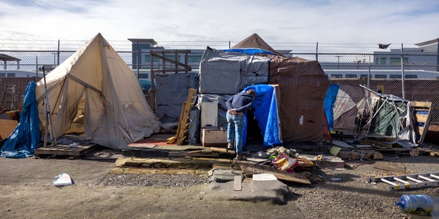 Kevin Dahlgren visits an encampment to speak with residents about moving to a homeless shelter on March 12, 2022 in Seattle, Washington.