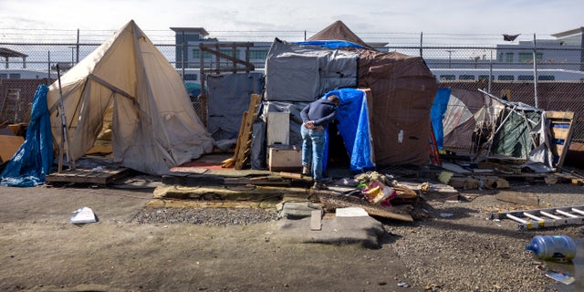 Kevin Dahlgren visits an encampment to speak with residents about moving to a homeless shelter on March 12, 2022, in Seattle, Washington.