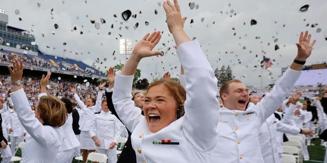 Erin Finley (front, center) of Downingtown, Pennsylvania, and her fellow U.S. Naval Academy graduates throw their hats into the air at the conclusion of their graduation and commissioning ceremony in the academy's Memorial Stadium on May 27, 2022, in Annapolis, Maryland. 