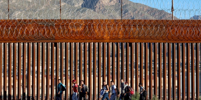 This file photo shows Venezuelan migrants walk along the U.S. Border fence after crossing the Rio Grande from Mexico to turn themselves in to the U.S. Border Patrol on September 22, 2022 in El Paso, Texas. 