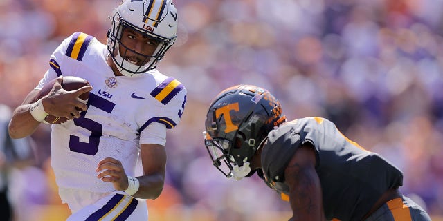Jayden Daniels, #5 of the LSU Tigers, runs with the ball as Jaylen McCollough, #2 of the Tennessee Volunteers, defends during the first half a game at Tiger Stadium on Oct. 8, 2022 in Baton Rouge, Louisiana.