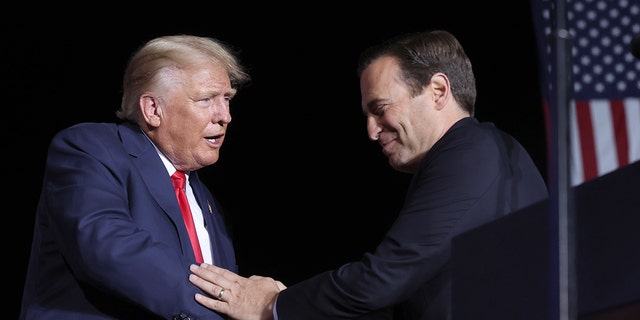 Nevada Republican Sente nominee Adam Laxalt greets former President Donald Trump on stage during a campaign rally at Minden-Tahoe Airport on October 08, 2022 in Minden, Nevada.  