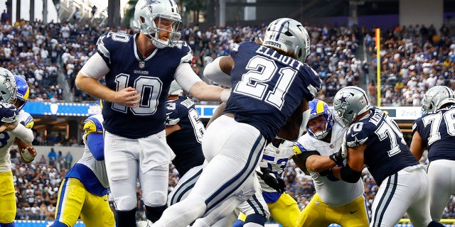 Cooper Rush of the Dallas Cowboys hands off to Ezekiel Elliott at SoFi Stadium on Oct. 9, 2022, in Inglewood, California.