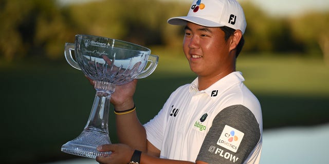 Tom Kim of South Korea poses with a trophy after winning the Shriners Children's Open at TPC Summerlin on October 9, 2022 in Las Vegas, Nevada. 