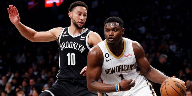 Zion Williamson, #1 of the New Orleans Pelicans, dribbles against Ben Simmons, #10 of the Brooklyn Nets, during the first half at Barclays Center on Oct. 19, 2022 in Brooklyn, New York.