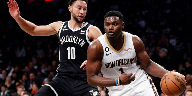 1 Zion Williamson of the New Orleans Pelicans, #10 of the Brooklyn Nets, dribbles against Ben Simmons during the first half at Barclays Center on October 19, 2022 in Brooklyn, New York.