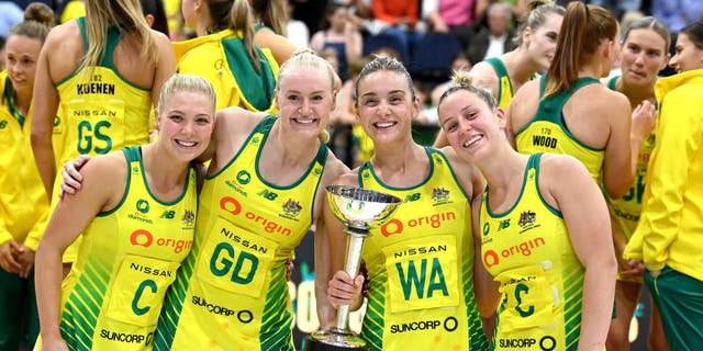 Australian netball players pose for a photo with the Constellation Cup as they celebrate victory after the Constellation Cup match between the Australia Diamonds and New Zealand Silver Ferns.