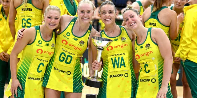 Australian netball players pose for a photo with the Constellation Cup as they celebrate victory after the Constellation Cup match between the Australia Diamonds and New Zealand Silver Ferns.