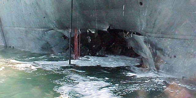 A gaping hole marred the port side of the Arleigh Burke-class guided missile destroyer USS Cole after a terrorist bomb exploded and killed 17 U.S. sailors and injured some 36 others during a refueling operation on October 12, 2000, in the port of Aden, Yemen. 