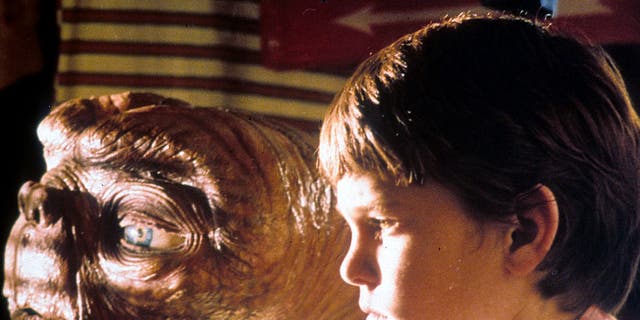 E.T. looks out the window with actor Henry Thomas in a scene from "E.T. The Extra-Terrestrial," 1982.