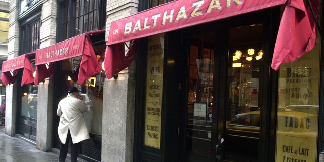 Stock photo of a pedestrian walking in front of the SoHo restaurant Balthazar in New York City.