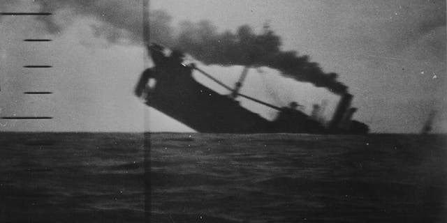 A view through the periscope of the American submarine USS Wahoo (SS-238) of its target, a Japanese merchant ship, sinking in the Pacific, during World War II, 1942. Crash test dummy inventor Samuel Alderson helped develop military technology for the U.S. government in World War II, including improved periscopes on submarines.