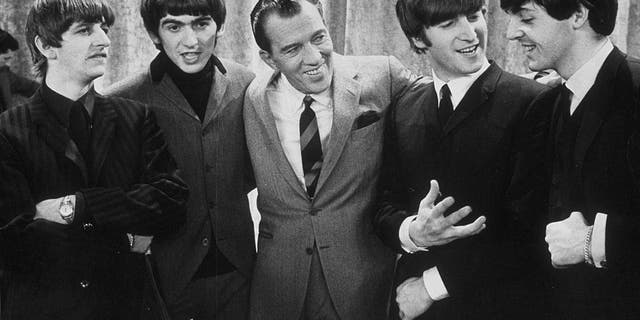 American TV host Ed Sullivan smiles while standing with the Beatles on the set of his television variety series, New York, Feb. 9, 1964. Left to right: Ringo Starr, George Harrison, Sullivan, John Lennon, Paul McCartney.