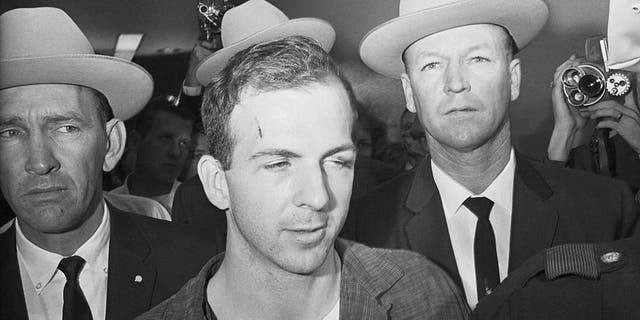 Texas Rangers escort accused Kennedy assassin Lee Harvey Oswald into a Dallas police facility.