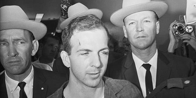 Texas Rangers escort accused Kennedy assassin Lee Harvey Oswald into a Dallas police facility.