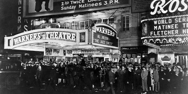 A huge crowd waits outside Warners' Theatre to see Al Jolson in The Jazz Singer (1927).