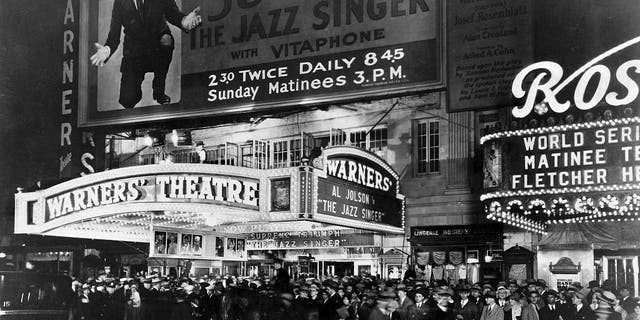 A huge crowd waits outside Warners' Theatre to see Al Jolson in The Jazz Singer (1927).