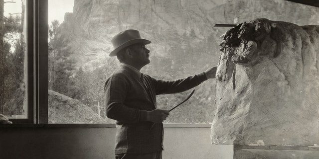 Gutzon Borglum (1867-1941), American sculptor, at work in his studio on the model for Mt. Rushmore. Photograph circa 1930s. 